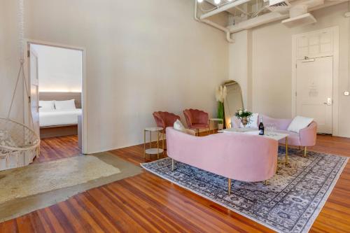 - un salon avec un canapé rose et un miroir dans l'établissement Inn at Blackstone, à Blackstone