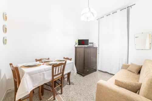 ein Wohnzimmer mit einem Tisch und einem Sofa in der Unterkunft Appartamento con AC-wi-fi- centro a 7 min in Savona