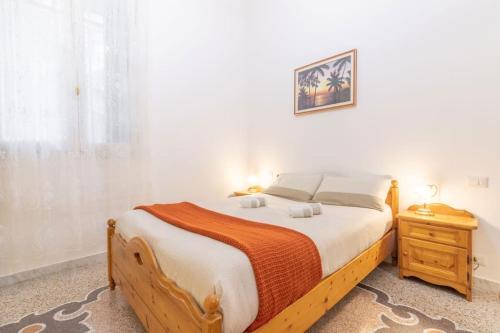 ein Schlafzimmer mit einem großen Holzbett und einem Nachttisch in der Unterkunft Appartamento con AC-wi-fi- centro a 7 min in Savona
