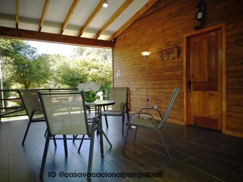 a patio with a table and chairs on a deck at Monoambiente Panguipulli in Panguipulli