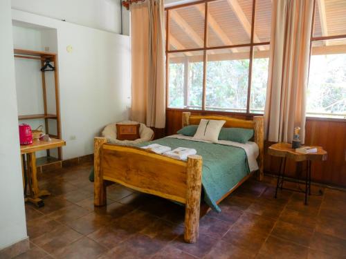 a bedroom with a bed and a large window at Wandari Lodge in Quince Mil