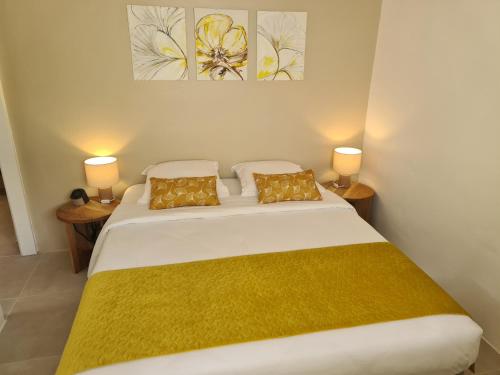 a bedroom with a large white bed with two lamps at La Villa Baie du Marin in Le Marin