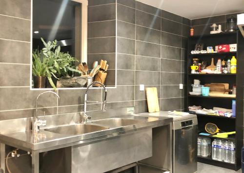 uma cozinha com um lavatório de aço inoxidável numa cozinha em Accomodatie in Villa Werschmatt em Kruth