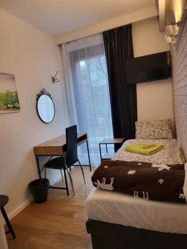 um quarto com uma cama, uma secretária e uma mesa em AMBER APARTAMENt #127 em Cracóvia