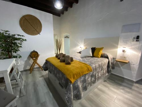 Un dormitorio con una cama con una manta amarilla encima. en Apartamento Jerez Sherry, en Jerez de la Frontera