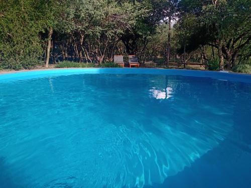 una gran piscina de agua azul con un banco en el fondo en los chañares de San Javier en San Javier