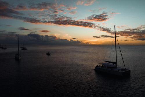 a boat sitting in the water at sunset at La Villa Baie du Marin in Le Marin