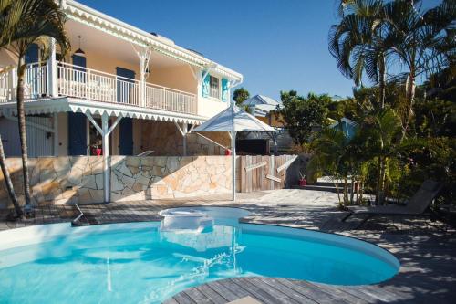 a swimming pool in front of a house at La Villa Baie du Marin in Le Marin