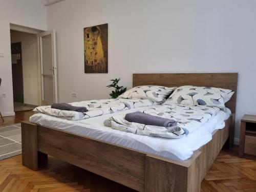 ein großes Bett mit weißer Bettwäsche und Kissen darauf in der Unterkunft Downtown Studio Apartman in Pécs