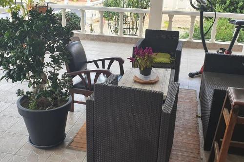 un patio con sillas y una mesa con macetas. en GITE Appartement 2/3 pers., en Bordères-sur-lʼÉchez