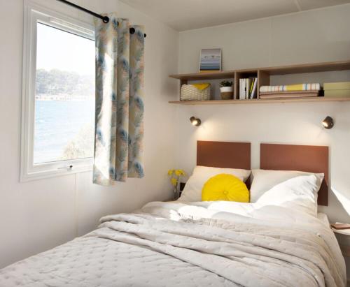 sypialnia z dużym łóżkiem i oknem w obiekcie Camping Marina Plage w mieście Vitrolles