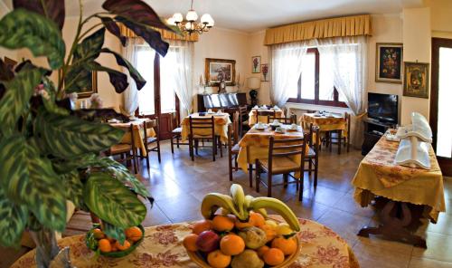 una sala de estar con mesas, sillas y fruta en una mesa. en Villa Santantonio, en Giardini Naxos