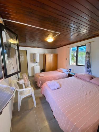 sypialnia z 2 łóżkami, stołem i krzesłami w obiekcie Rincon de Las Condes w mieście Santiago