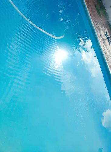 a pool with a reflection of the sun in the water at Ramenos in Kempton Park