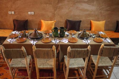 a table with plates and utensils on it at Berber Nomad Kasbah in Nkob