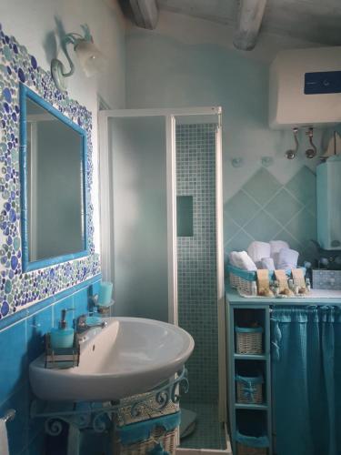 Villetta Tavolara في بورتو سان باولو: حمام مع حوض ومغسلة ومرآة