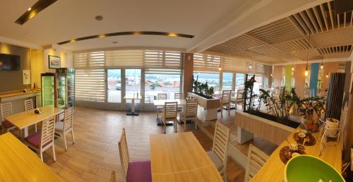 um restaurante com mesas e cadeiras e uma grande janela em Hotel Rivero A&S em Mostar