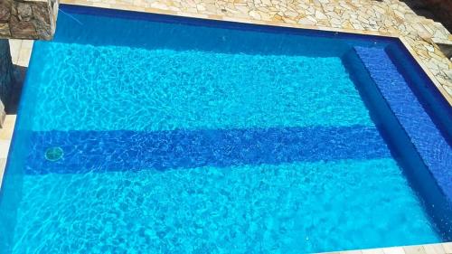 a blue swimming pool with blue water at Casa de praia in Itanhaém
