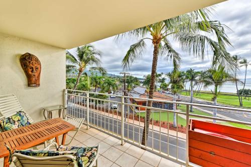 a balcony with a table and chairs and palm trees at Condo with Private Lanai, Ocean View and On-Site Pool! in Kihei
