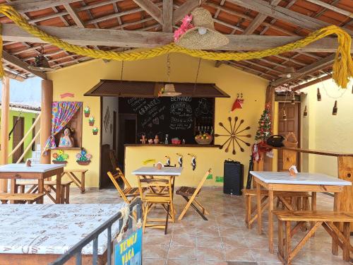 een restaurant met tafels en een schoolbord aan de muur bij Cantinho da Rapha in Ilha de Boipeba