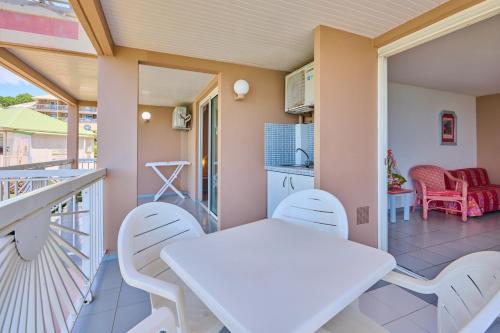 a balcony with a white table and chairs at Diamant Beach in Le Diamant