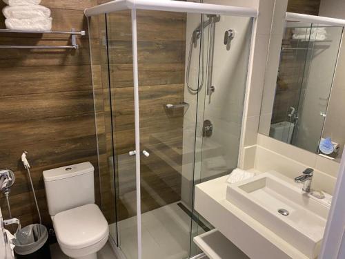 a bathroom with a shower and a toilet and a sink at Carpe Diem Hotel Duplex in Campos do Jordão