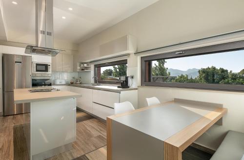 a kitchen with white cabinets and a large window at Villa Enny, 3 BD with Private Heated Pool in Ayiá