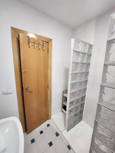 baño con aseo y puerta de madera en eXperience Rooms Valencia, en Valencia