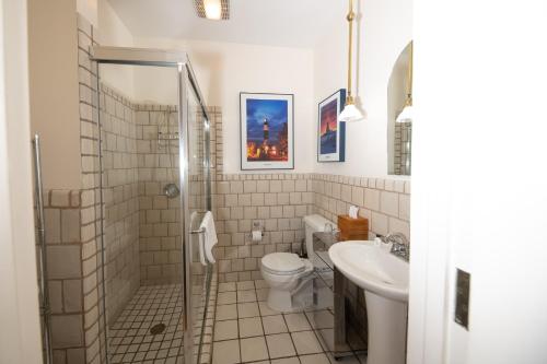 a bathroom with a shower and a toilet and a sink at Cartier Mansion in Ludington