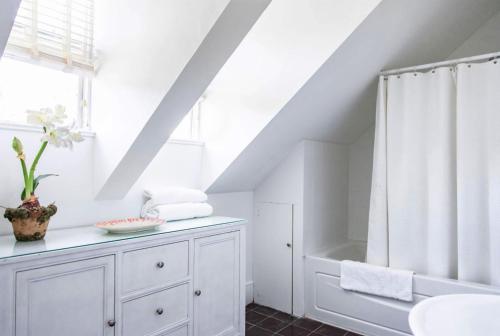 a white bathroom with a shower and a sink at Folly & Guest House home in Governorʼs Harbour