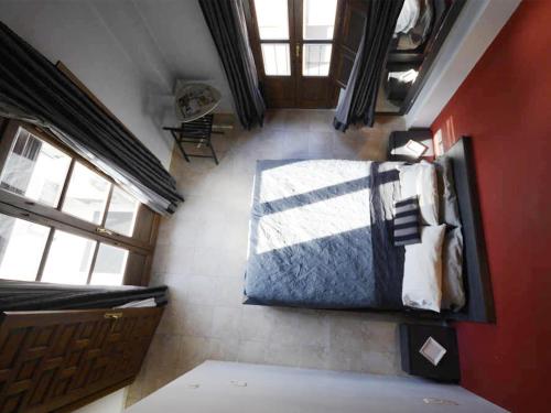 a bedroom with a bed and a red wall at Loft wifi Centro espectacular terraza con todos los servicios in Granada