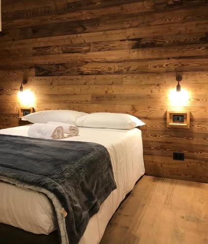a bedroom with a bed in a wooden wall at 4Seasons house Faure in Sauze dʼOulx