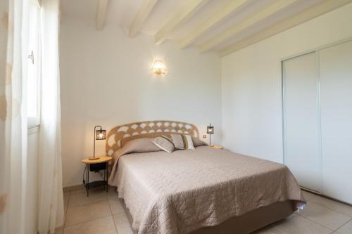 una camera bianca con letto e tavolino di Résidence Spelonca a Corbara