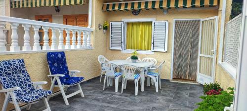 patio ze stołem i krzesłami na ganku w obiekcie Bungalow Deluxe Gran Alacant w mieście Gran Alacant