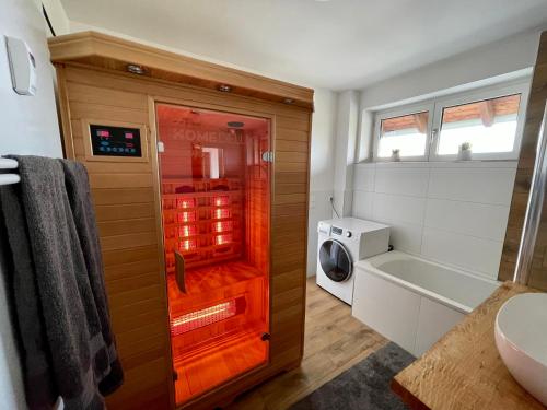 a bathroom with a tub and a washing machine at Modernes Appartment mit Sauna nahe Burg im Spreewald in Vetschau