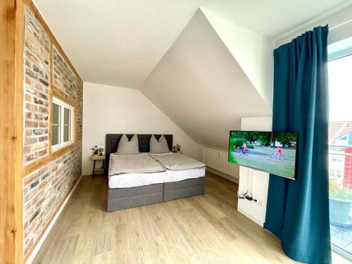 a bedroom with a bed and a flat screen tv at Modernes Appartment mit Sauna nahe Burg im Spreewald in Vetschau