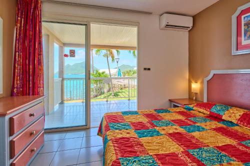 a bedroom with a bed and a balcony at Diamant Beach in Le Diamant