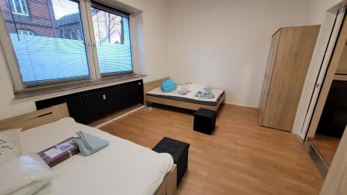 een kamer met 2 bedden, een tafel en een raam bij Komfortwohnungen Oberhausen in Oberhausen