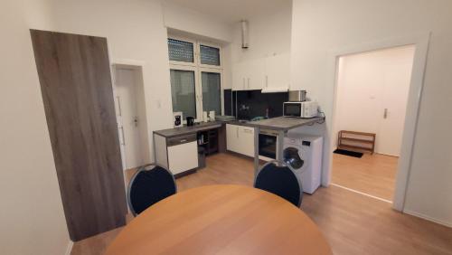een keuken met een tafel en stoelen in een kamer bij Komfortwohnungen Oberhausen in Oberhausen