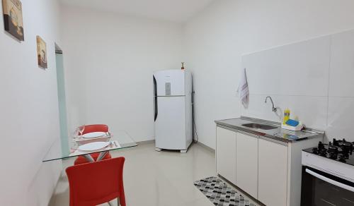 eine Küche mit einem Kühlschrank und einem roten Stuhl in der Unterkunft Apartamento no centro próximo a JK. in Palmas