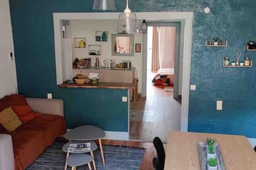 - un salon avec un canapé et un mur bleu dans l'établissement Côté Jardin, à Ornans