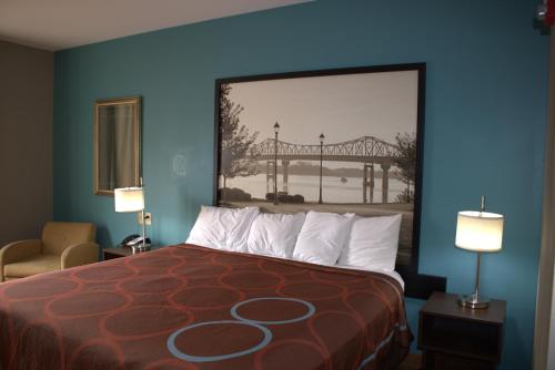 a bedroom with a bed with a bridge in the background at Super 8 by Wyndham Rainsville in Rainsville