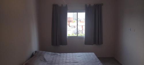 1 dormitorio con cama y ventana en DEPARTAMENTO VILLA CARLOS PAZ CENTRO en Villa Carlos Paz