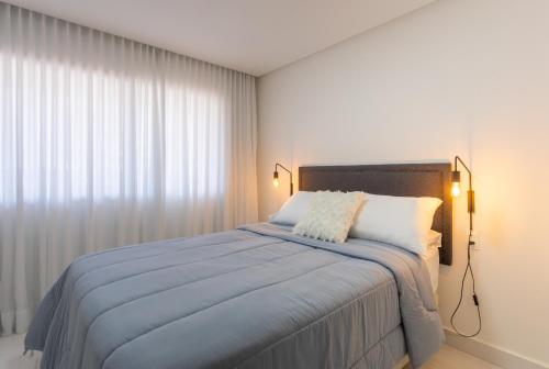 1 dormitorio con 1 cama con manta azul en Luxuoso Apartamento na Praia de Cabo Branco, en João Pessoa