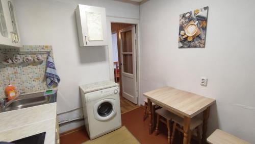 uma pequena cozinha com uma máquina de lavar roupa e uma mesa em Sunday em Chornomorsk