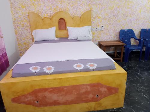a bed in a room with two blue chairs at Ndiro Beach House Kendwa in Kendwa