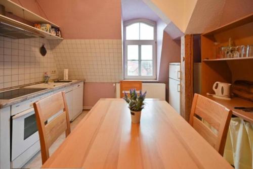 una cocina con mesa de madera y sillas. en Weiße Villa Whg. 2, en Duderstadt