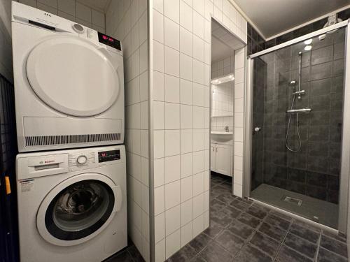 y baño con lavadora y ducha. en Stetind - Modern apartment with free parking en Narvik