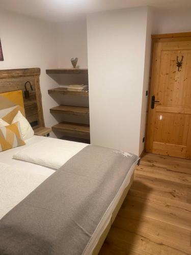 a bedroom with two beds and a wooden door at Haus Almweg in Kirchberg in Tirol