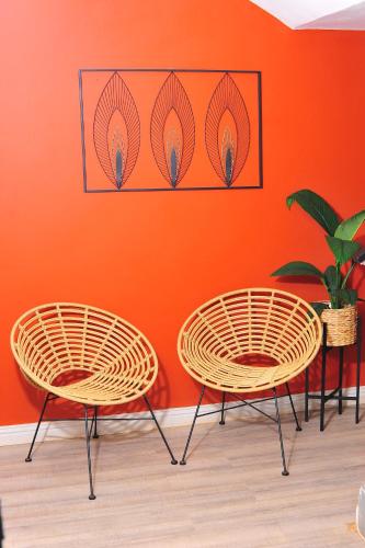 two chairs in front of an orange wall at Square Connexions Guest House in Gaborone